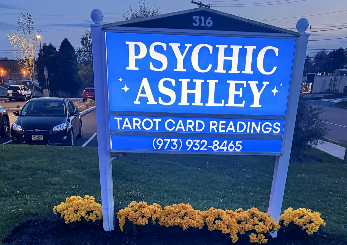 The Psychic Ashley sign glowing at dusk on Route 46 — look for it at 316 US Highway 46